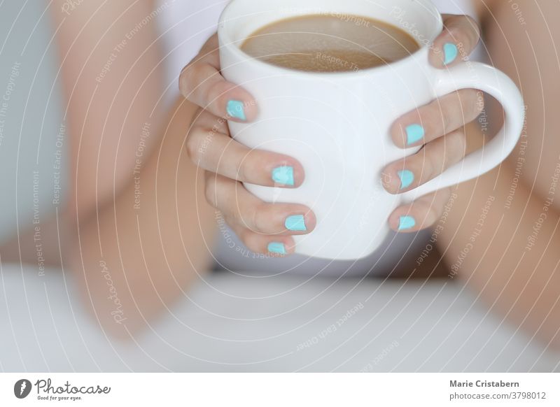 Hände mit blauer Nagelfarbe halten eine Tasse Kaffee, offen friedliche Morgenroutine Beteiligung Lifestyle Alltagsleben Windstille entspannend Wärme Komfort