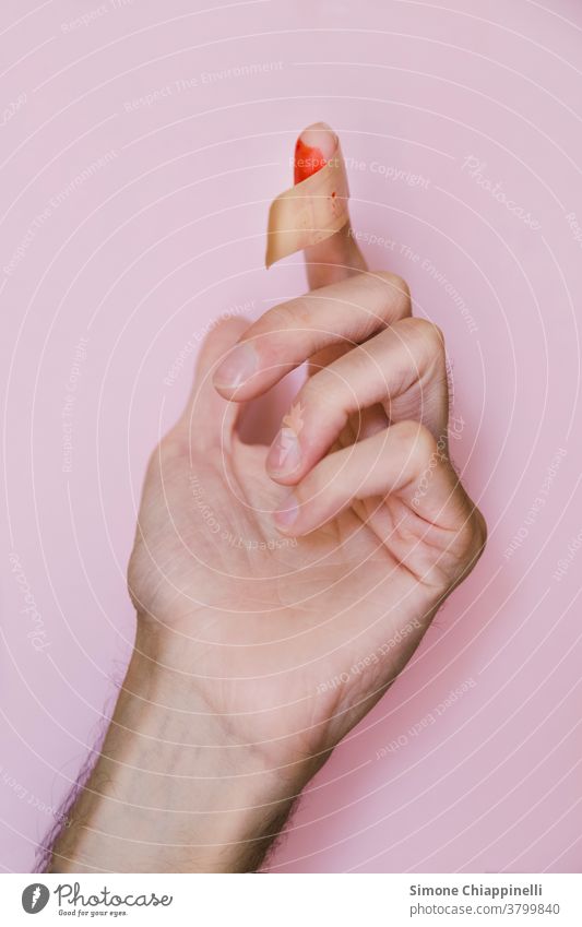 Blutiger Finger mit Fleck auf rosa Hintergrund Hand Farbfoto rot Hintergrund neutral wehtun Wunde Haut Schmerz Detailaufnahme Pflege Gesundheitswesen Medikament