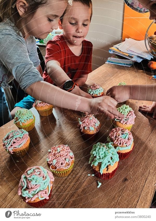 Kinder backen Muffins, bereiten Zutaten vor, dekorieren Kekse Cupcake dekorierend vorbereitend Essen zubereiten Familie heimisch Zusammensein Kindheit Glück