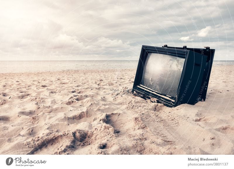 Alter kaputter Fernseher am Strand bei Sonnenuntergang. Fernsehen Sand gebrochen Bildschirm veraltet Nachrichten Natur Technik & Technologie Himmel friedlich