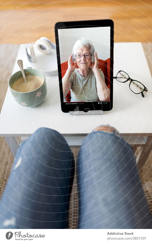 Frau schaut Video auf Tablet zu Hause zuschauen Tablette unterhalten benutzend Kaffee Wochenende heimwärts online Tisch Tasse trinken Cappuccino