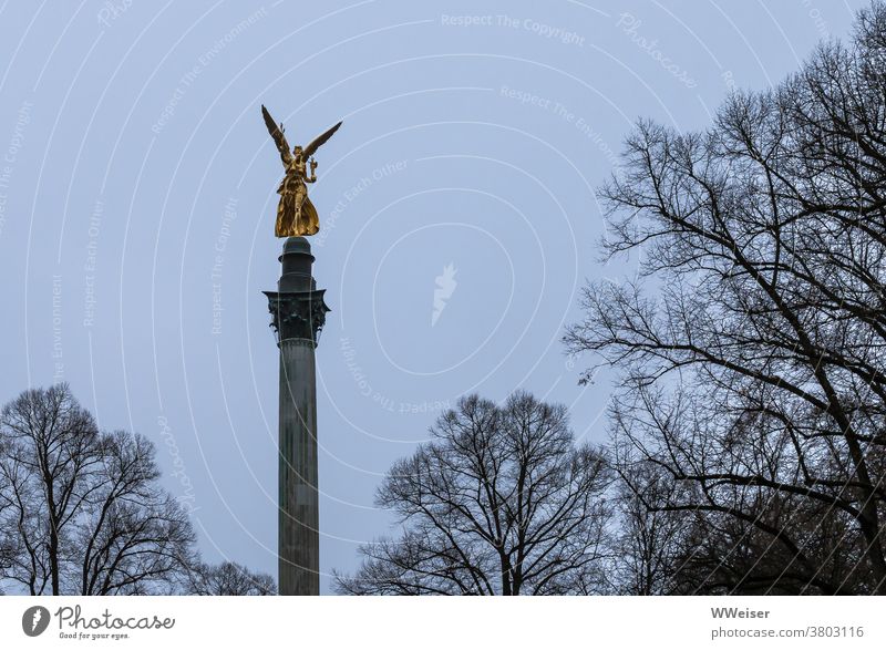 Der Friedensengel ragt golden in den grauen Novemberhimmel München Friedensdenkmal Denkmal Bayern Krieg Figur Engelsfigur Bogenhausen Himmel Park Bäume graublau