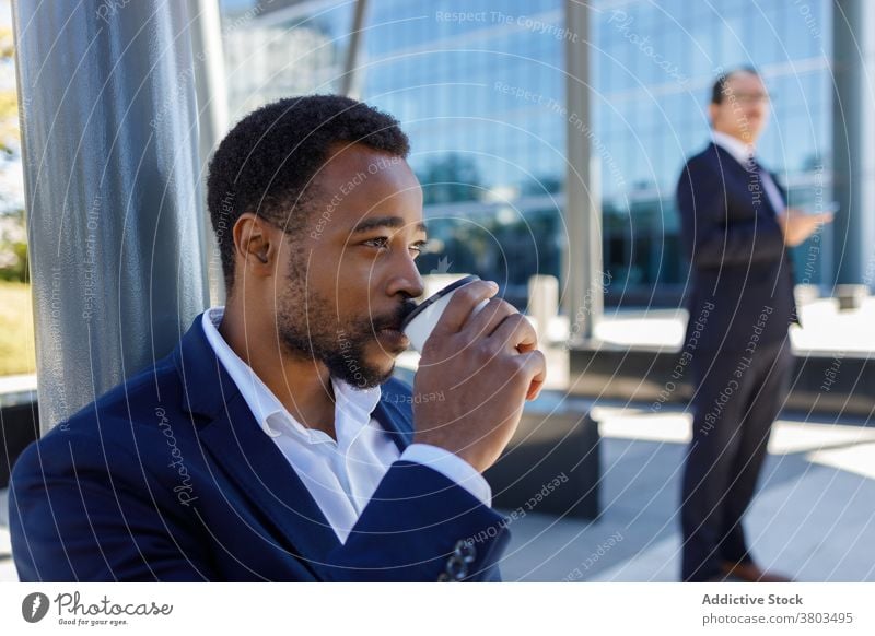 Junge schwarze Geschäftsmann trinken Kaffee auf der Straße während der Pause zu gehen Mann Imbissbude Fokus ruhen Unternehmer Kaffeepause Stil selbstbewusst