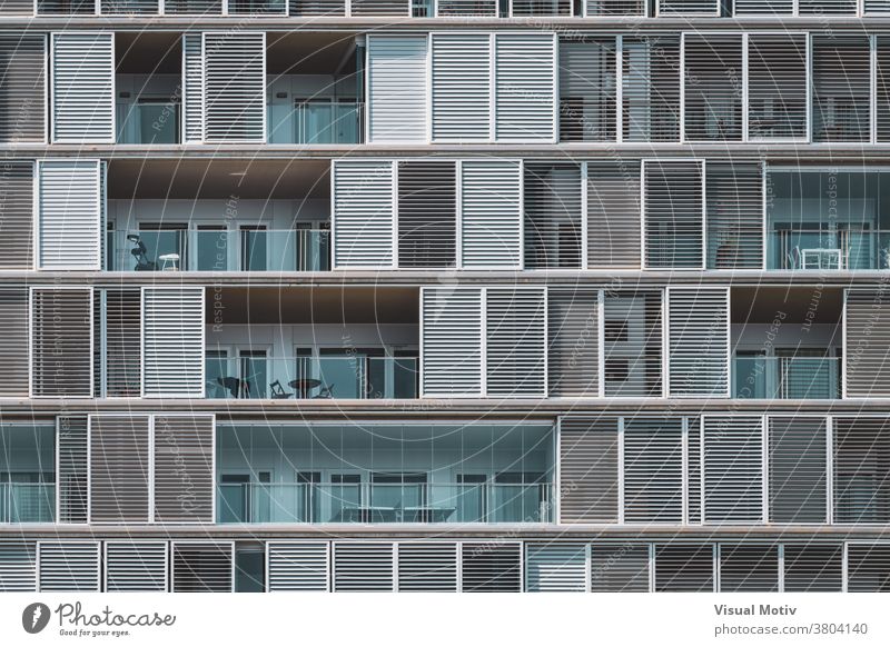 Geometrische Frontalansicht der Fensterläden und Balkone eines städtischen Gebäudes, die in fortlaufenden Reihen angeordnet sind Fassade urban Architektur