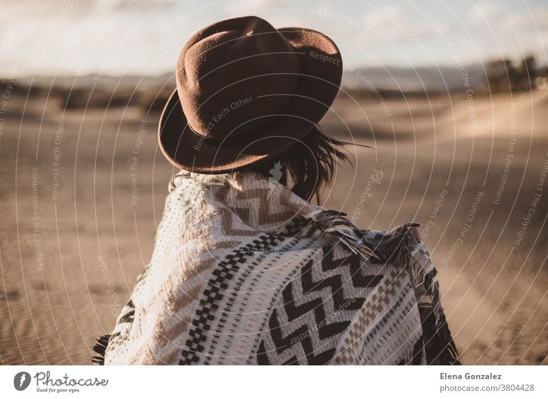 junge Frau von rückwärts mit Schal und Hut in der Wüste bei Sonnenuntergang zurück Kopftuch wüst windig Wind windiger Tag im Freien allein Düne Mädchen