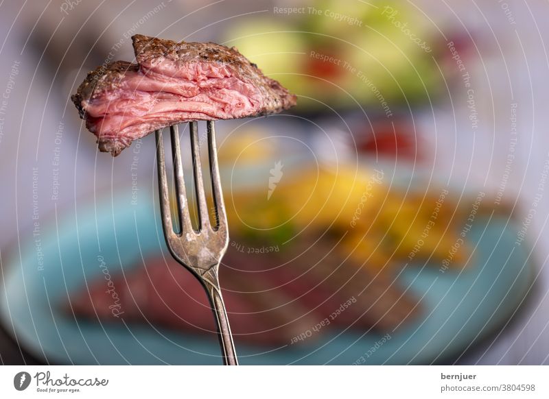 Scheibe Steak auf einer Gabel rustikal Rindfleischsteak mittel Sirloin Braten geröstet Fleisch saftig geschnitten rot Essen roh selten Hintergrund Teller