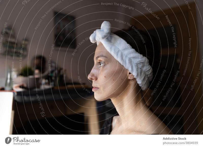 Konzentrierte junge Frau, die sich auf das Make-up vorbereitet vorbereiten Stirnband absorbiert ernst Konzentration Kosmetikerin besinnlich Mode Fokus