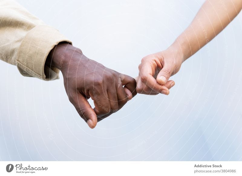 Crop multirassischen Paar hält kleine Finger Händchenhalten Haltegriff mit kleinem Finger Liebe Partnerschaft Zusammensein sanft Bonden Pflege lässig Stil Hand