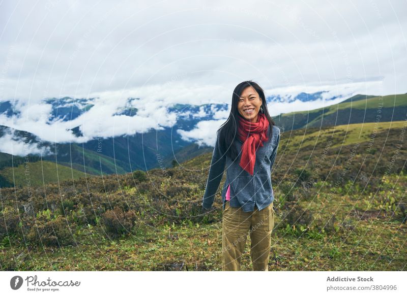 Glückliche ethnische weibliche Wanderer im Gebirgstal Frau reisen Hügel Tal Wiese Berge u. Gebirge Hochland Fernweh schlanke heiter Zahnfarbenes Lächeln dünn