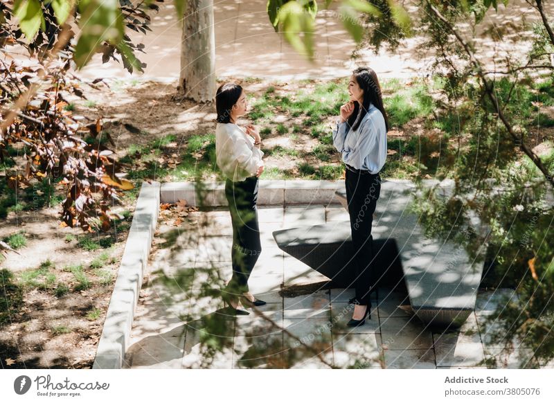Glückliche asiatische Frauen entspannen im Park und Spaß haben Lachen Kommunizieren reden Zusammensein Zeit verbringen heiter tratschen Freundschaft Talkrunde