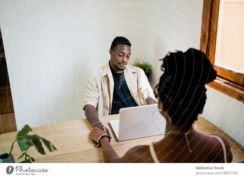 Glückliche schwarze Frau vor männlichem Arbeitgeber Paar kuscheln Laptop Erfrischung Appartement Pause freiberuflich Freizeit Partnerschaft Afroamerikaner