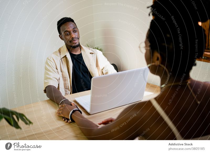 Glückliche schwarze Frau vor männlichem Arbeitgeber Paar kuscheln Laptop Erfrischung Appartement Pause freiberuflich Freizeit Partnerschaft Afroamerikaner