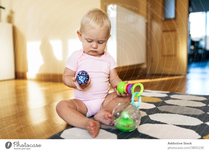 Nettes Kleinkind spielt mit Spielzeug auf dem Boden Baby spielen Interesse niedlich unschuldig heimwärts Kindheit neugierig spielerisch Freude Mädchen Säugling