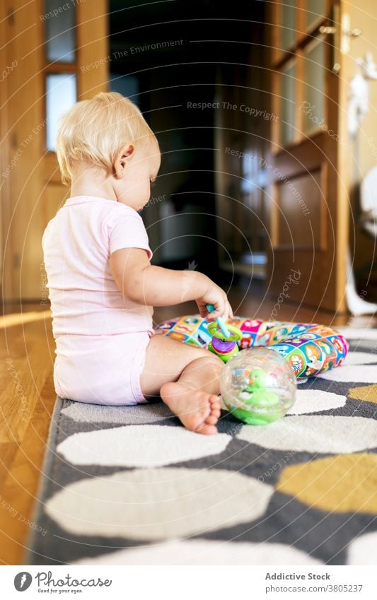 Baby Mädchen spielt auf dem Boden spielen Stock heimwärts Glück Spaß haben Spielzeug Grimasse Liebe Tochter Zusammensein bezaubernd jung Kind Kleinkind