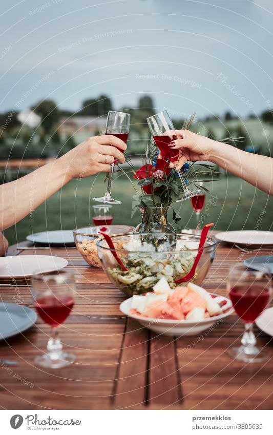 Ehepaar macht Toast während des Sommers beim Abendessen im Freien in einem Hausgarten heimwärts Festessen habend Picknick Lebensmittel Mann Zusammensein Frau