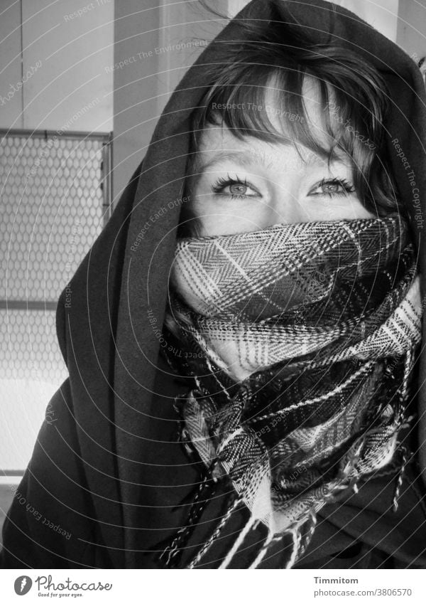 Frau wartet in der Kälte Gesicht Kopf Augen Haare Schal Tuch Kapuze feminin Porträt Blick Schwarzweißfoto Gelassenheit Blick in die Kamera schön