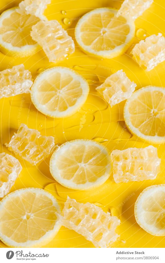 Bienenwaben mit frischen Zitronenscheiben auf gelbem Hintergrund Wabe Scheibe Liebling süß geschmackvoll Zitrusfrüchte Frucht Tropf farbenfroh Leckerbissen