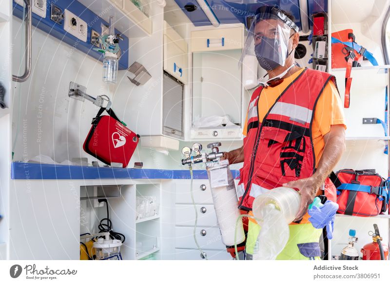 Anonymer Rettungsschwimmer im Visier mit medizinischer Ausrüstung im Krankenwagen Gerät schützend Schutzschild Uniform Beruf Arbeit PKW Arbeiter Erste Hilfe