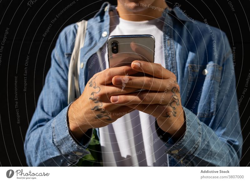 Anonymer Mann mit Smartphone Tasche benutzend Mobile Telefon Lifestyle jung modern Browsen Gerät Apparatur Internet online Anschluss Surfen Text elektronisch