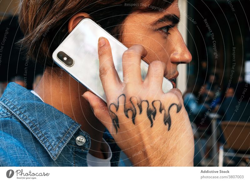 Junger Mann mit Tattoo im Gespräch am Telefon Smartphone reden Anruf Mobile Hipster Kommunizieren modern jung männlich Gerät Apparatur Anschluss sprechen