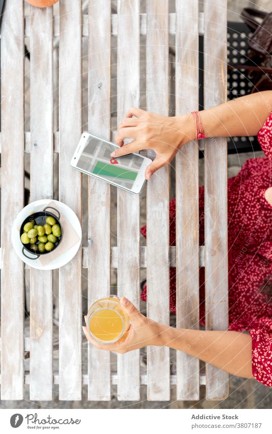 Crop Frau mit Getränk berühren Bildschirm auf Smartphone im Café Touchscreen Landkarte Anwendung Örtlichkeit Ikon benutzend Apparatur oliv Schalen & Schüsseln