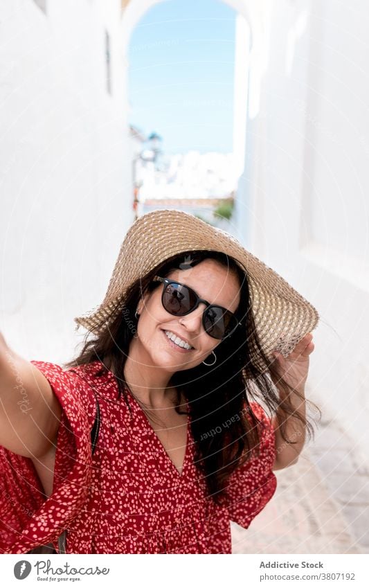 Glücklicher Tourist mit Sonnenbrille auf schmaler Straße in Griechenland Gebäude heiter Architektur Stil Urlaub Sommer weiß Dorf Rhodos Insel stylisch Frau