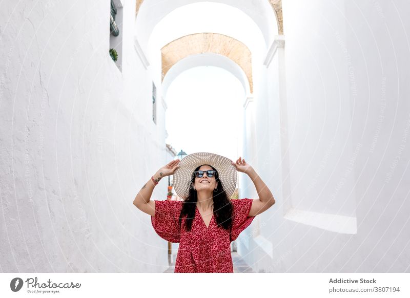 Reisende Frau mit Strohhut erkundet das Weiße Dorf auf Rhodos Reisender Arme hochgezogen erkunden Architektur Haus Straße Ausflug gealtert Sommer Tourist