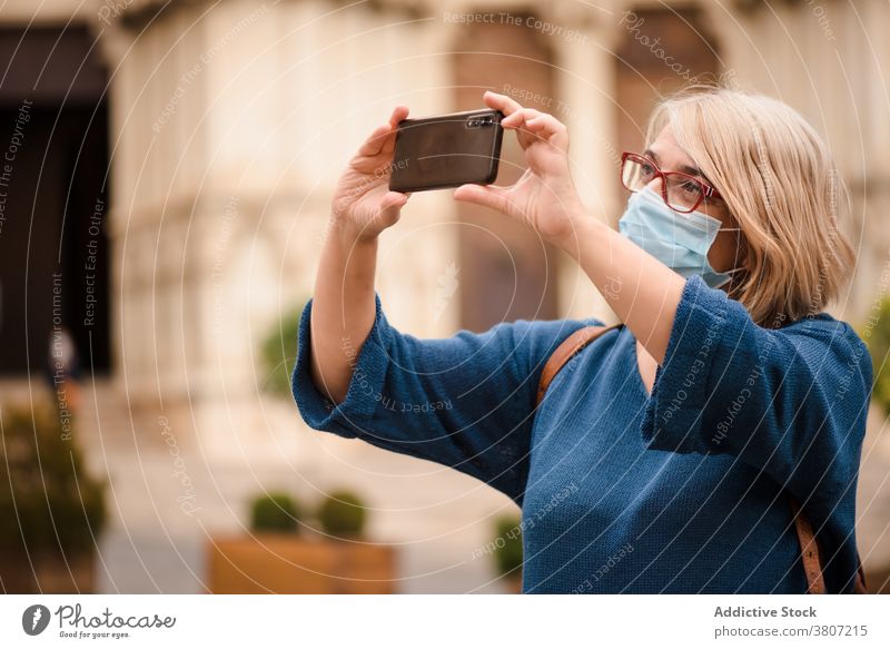 Frau mit Schutzmaske beim Fotografieren alter Gebäude Reisender fotografieren Stadt Mundschutz Coronavirus Smartphone Architektur Sightseeing besuchen Bund 19