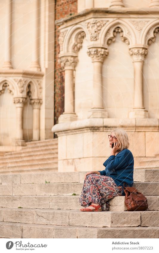 Reisende Frau in Maske spricht am Telefon in der Nähe von antiken Gebäude Reisender Smartphone reden mittelalterlich historisch Treppe Stadt Mundschutz