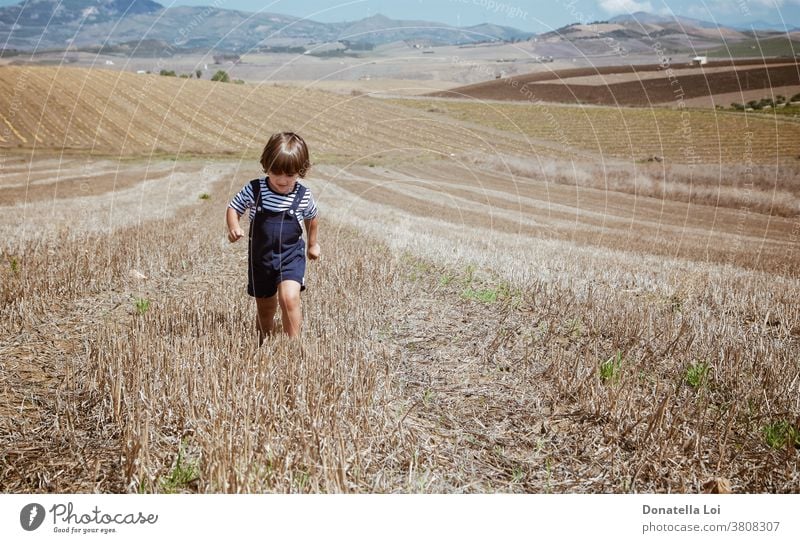 Kleiner Junge in ländlichen Landschaften 3 Jahre Agrarlandschaft allein Reisig lässig Kaukasier Kind Kindheit Bereiche grün Freude kleiner Junge männlich Berge
