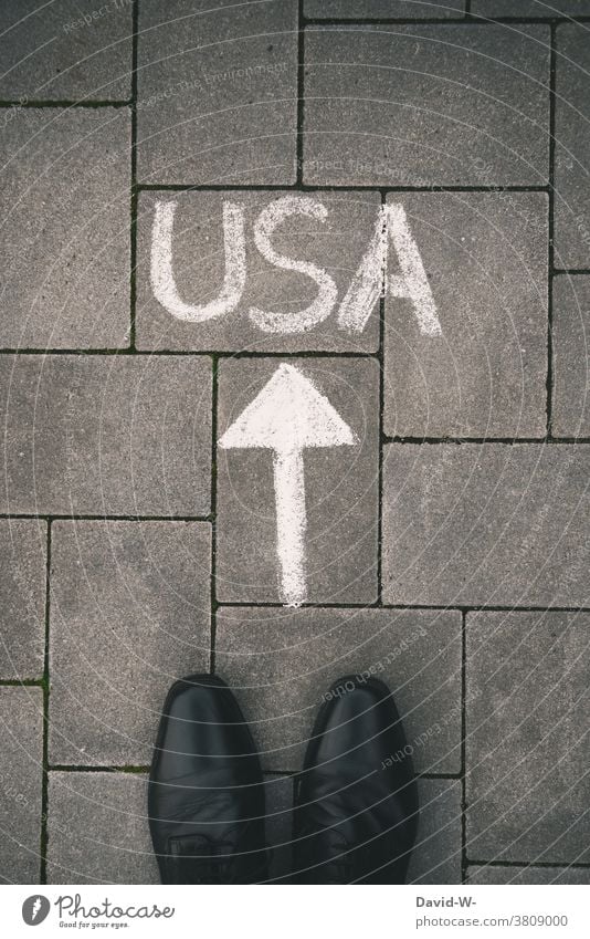 Füße und Pfeil in Richtung USA Amerika Business Thema Boden Kreide Wort Weltmacht Ziel richtungweisend