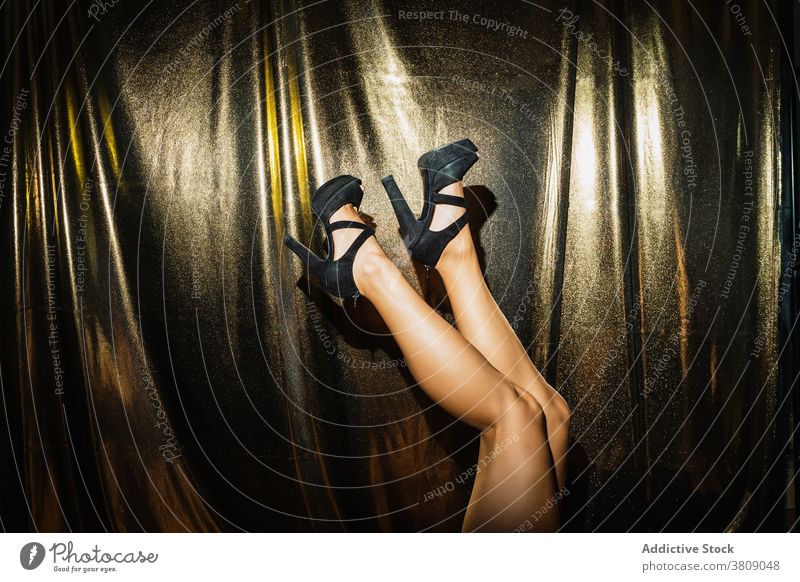 Frau mit schlanken Beinen und in hohen Absätzen auf Party Damenschuhe Glamour Schuh ausgefallen Schuhe trendy golden schwarz Mode Stil elegant Veranstaltung