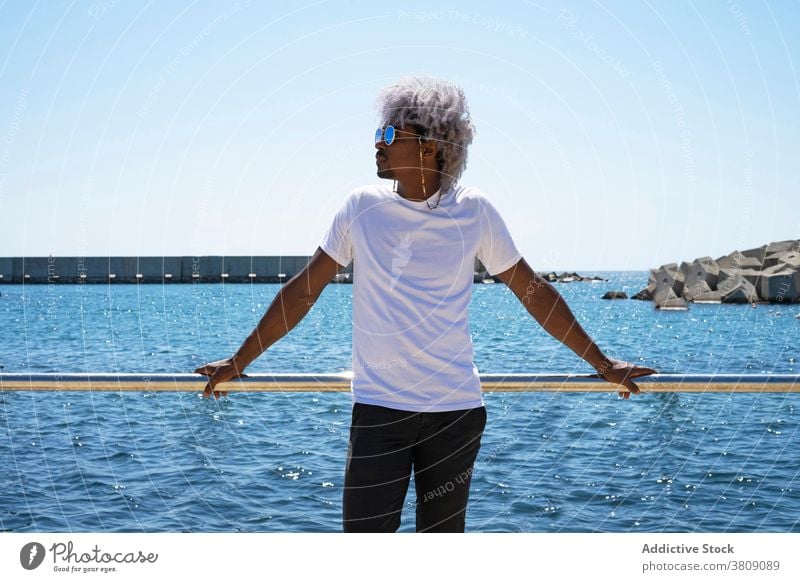 Schwarzer Mann mit Afro Haare entspannen vor dem Strand und die entspannend MEER am Strand entspannen Sommer Erholung Afrohaar Afro-Mann Windstille Ferien
