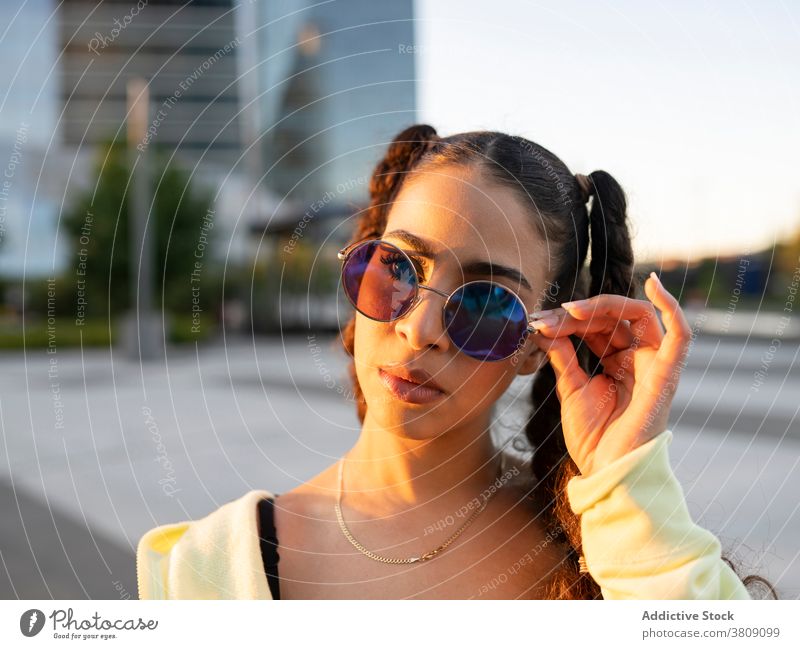 Coole junge ethnische Dame entspannt auf der Straße Frau sich[Akk] entspannen Training Verlockung Athlet trendy Großstadt Sonnenbrille Wellness Brille stylisch