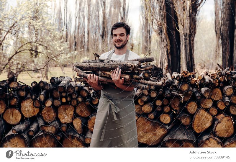 Mann nimmt Brennholz im Wald Picknick Totholz Ast Natur Schürze Haufen Holz männlich Sommer Baum Umwelt ländlich Landschaft frisch Saison vorbereiten hölzern