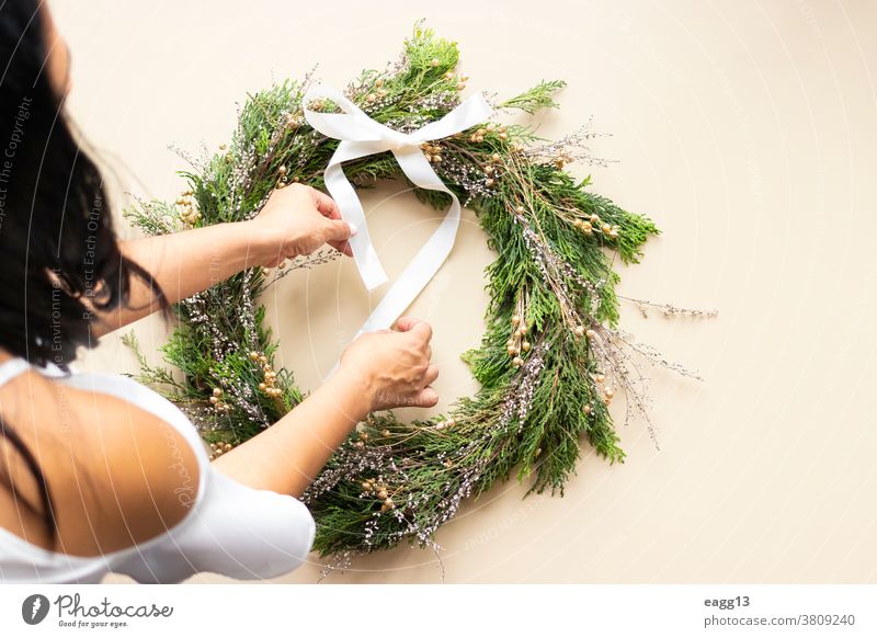 Süße Frau schmückt Adventskranz mit ihren Händen Weihnachten Ordnung weihnachtszeit kreisen Konzept kreieren kreativ Kreativität Dezember dekorieren dekorierend