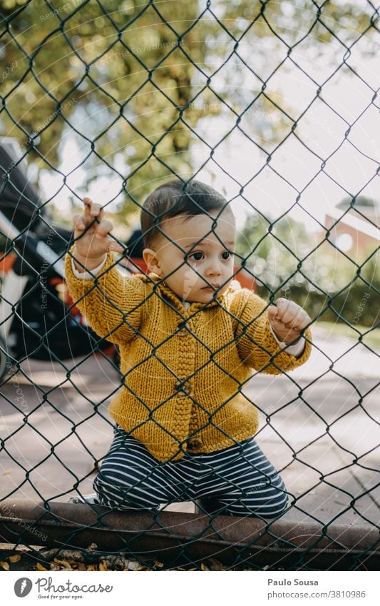 Kind auf einem Zaun haltend Barriere gesperrt Sicherheit Kindergarten Borte Schutz Draht Maschendraht Kindheit Beteiligung Freiheit Kaukasier Kleinkind