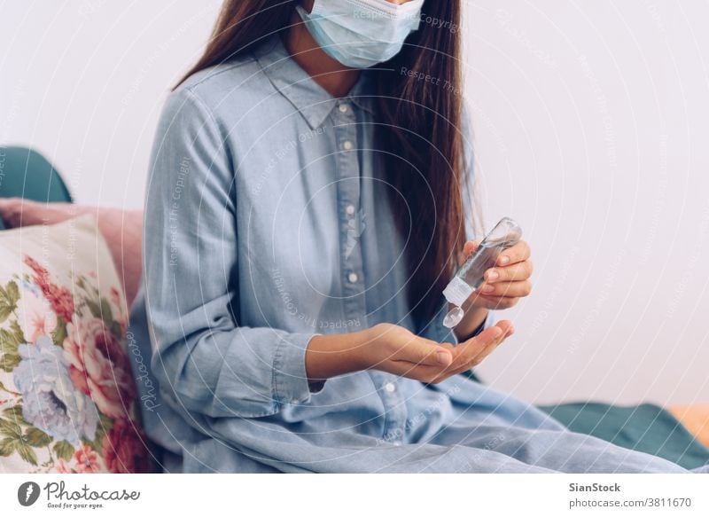 Coronavirus-Konzept. Ein Mädchen in ihrer Wohnung hat sich zum Schutz vor dem Coronavirus ein antiseptisches Gel auf die Hände aufgetragen. Weltweiter Aufruf, zu Hause zu bleiben.