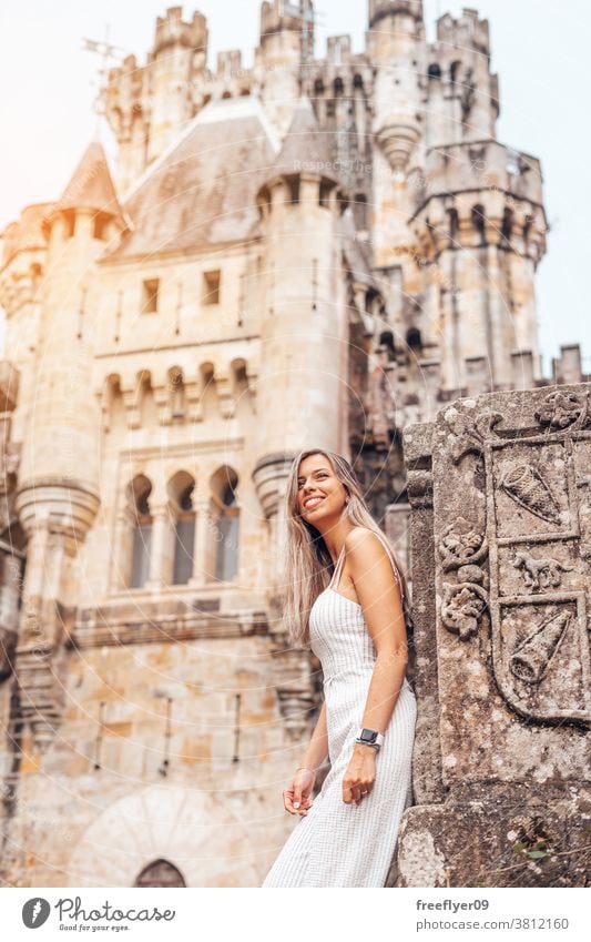 Junge Frau vor einer mittelalterlichen Burg Tourist blond jung 20s Tourismus reisen posierend Burg oder Schloss butron Lehnen Baskenland Spanien wandern