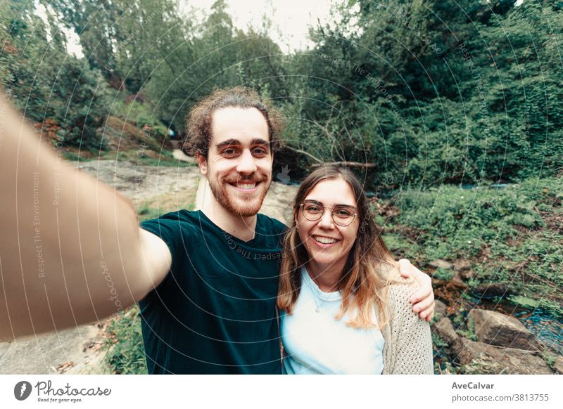 Junges Paar beim Selbermachen im Wald beim Lächeln reisen Erwachsener Wanderung Klippe Länge Feiertag Fotokamera Gedächtnis Porträt Frau Freund Selbst jung