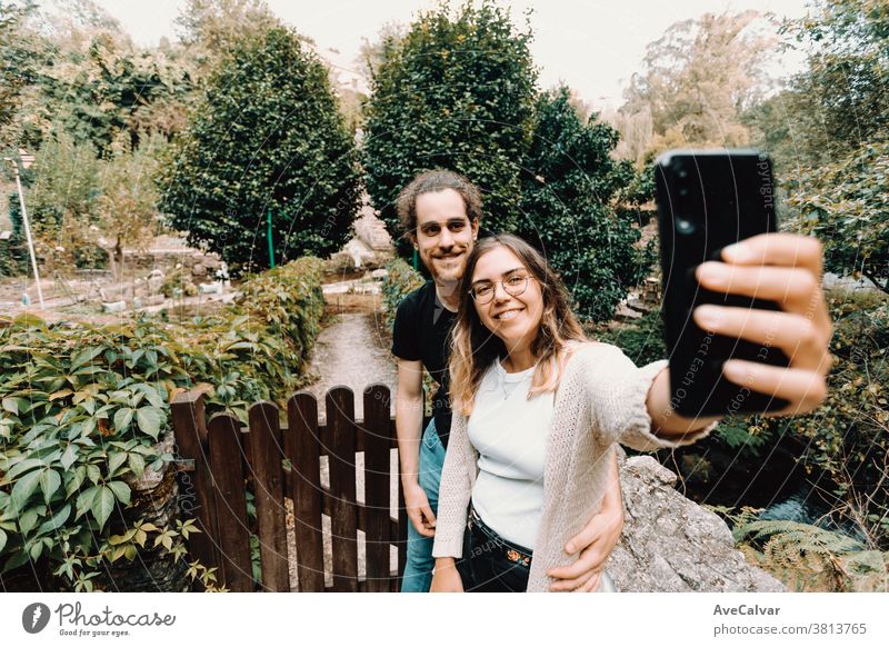 Junges und lächelndes Paar beim Selfie vor einem schönen ländlichen Haus Selbstporträt Spaß Smartphone Lifestyle Sommer Lächeln Zusammensein Liebe männlich Mann