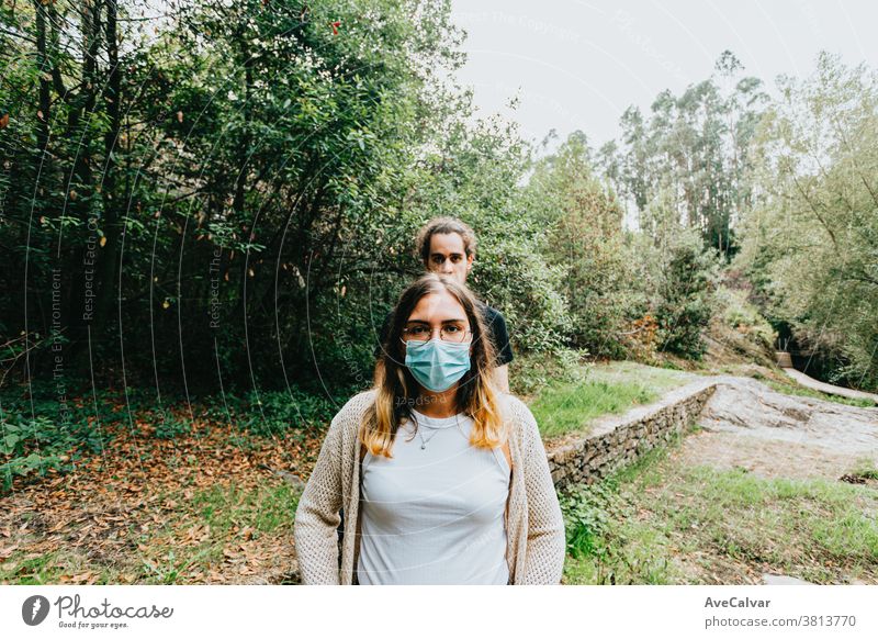 Frontalaufnahme eines ernsthaften Paares mit aufgesetzten Masken im Wald Foto Menschen ruhen Mobile Mitteilung Handy Park Teenager Glück Selfie