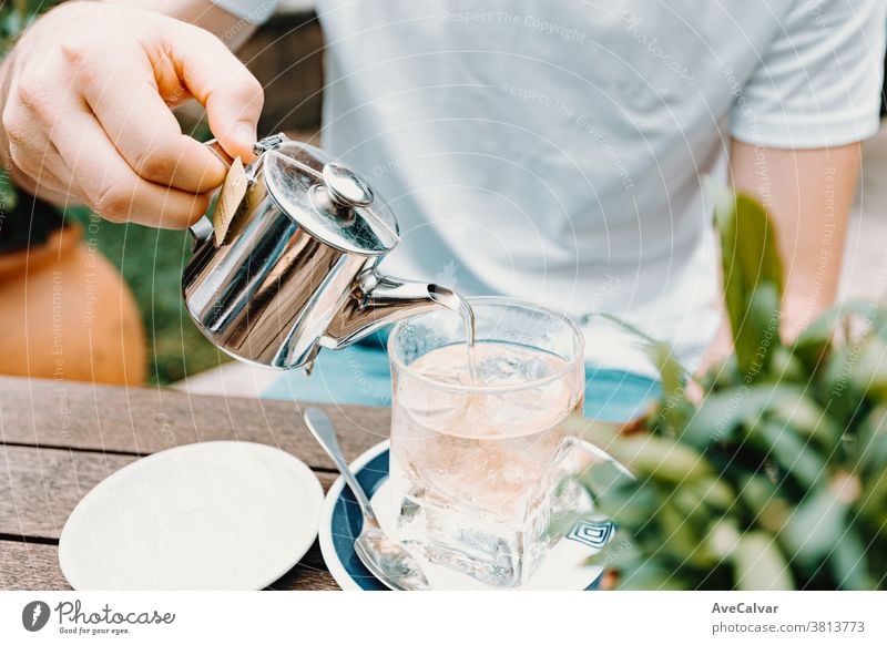 Junger Mann serviert einen Eistee in einer modernen Bar trocknen schließen Tee Kraut erwärmen vereinzelt Gesundheit Asien trinken Teetasse Frühstück Hand Gießen