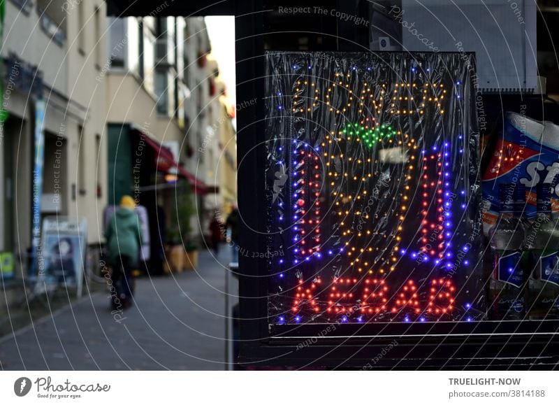 Schnell-im-Biss Gourmet Kiosk auf dem spärlich bevölkerten Fußweg einer Geschäftsstraße mit bunt leuchtendem Werbe Display, das die Worte Döner und Kebab und einen Grill mit Fleisch Spieß signalisiert