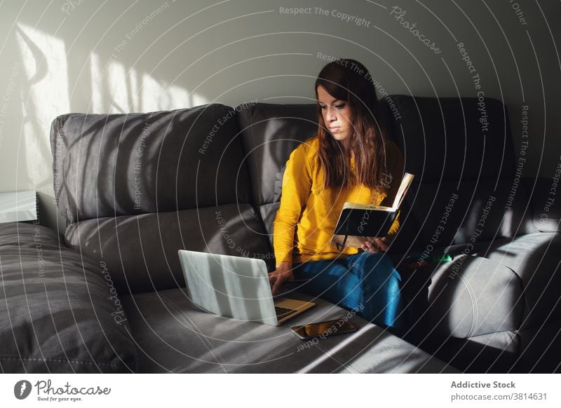 Seriöse Frau mit Laptop und Notebook arbeiten zu Hause Arbeit benutzend abgelegen freiberuflich beschäftigt modern jung Gerät Job Apparatur Konzentration