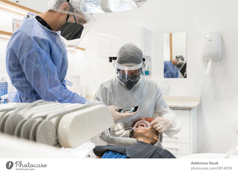 Zahnärzte beim Fotografieren der Zähne eines Patienten Zahnarzt fotografieren Smartphone geduldig Zahnmedizin Stomatologie Gerät dental professionell Klinik