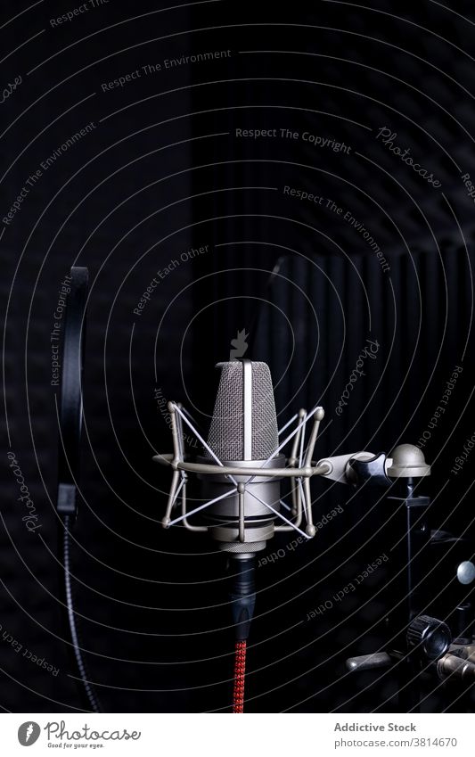 Modernes Mikrofon im dunklen Studio Aufzeichnen Atelier Musik schalldicht schäumen Gerät dunkel modern Klang Audio professionell Apparatur Gesang Melodie