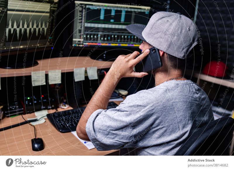 Männlicher Musiker, der im Studio arbeitet und mit einem Handy spricht Aufzeichnen Gerät Atelier Mann Arbeit Smartphone sprechen reden männlich Apparatur
