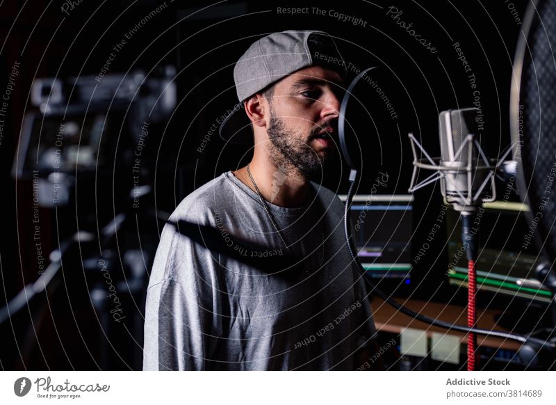 Männlicher Blogger, der ein Video im Musikstudio aufnimmt Aufzeichnen Musiker Mann Atelier Fotokamera Influencer männlich professionell Hobby modern Sänger