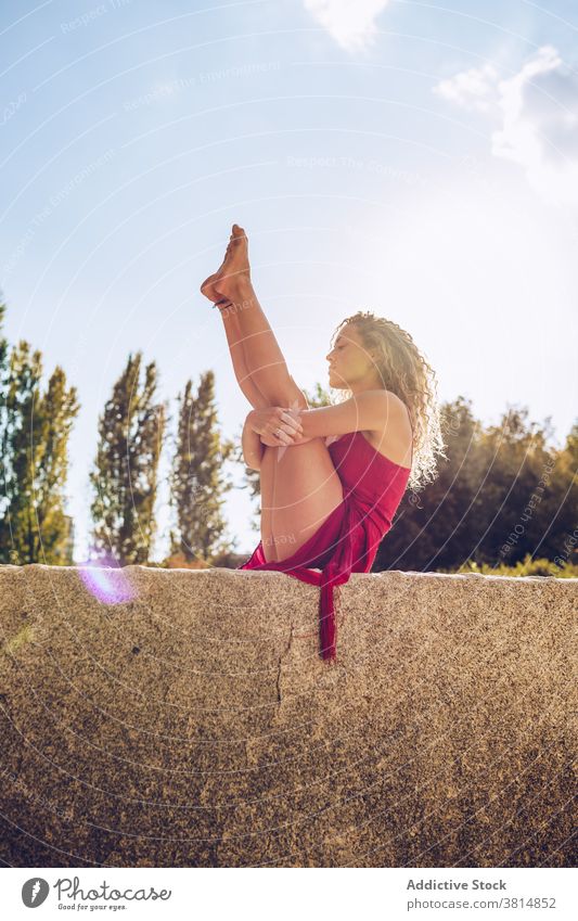 Frau in sitzender Balancierhaltung übt Yoga im Park beweglich Dehnung Gleichgewicht Boot urdhva mukha pascimottanasana Asana Pose üben positionieren schlank